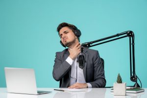 Podcaster experiencing vocal fatigue during a long recording session, showing the strain of extended speaking