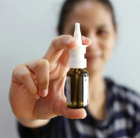 Patient using a nasal steroid spray correctly to relieve chronic nasal congestion and inflammation